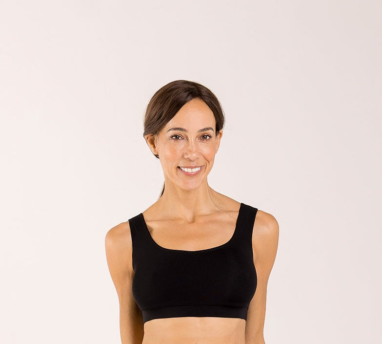 Woman wearing a black crop top bra made from seaweed to help alleviate the symptoms of menopause 