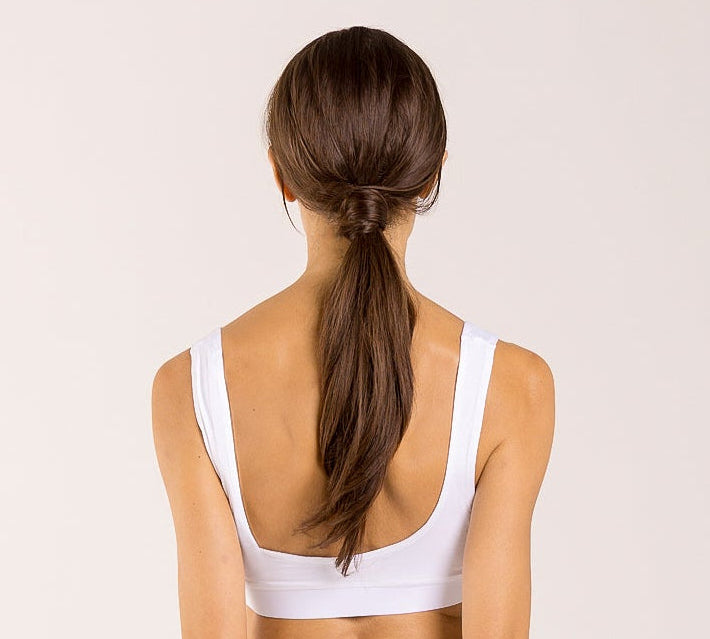 Woman wearing a white crop top made from seaweed to help alleviate the symptoms of menopause. 