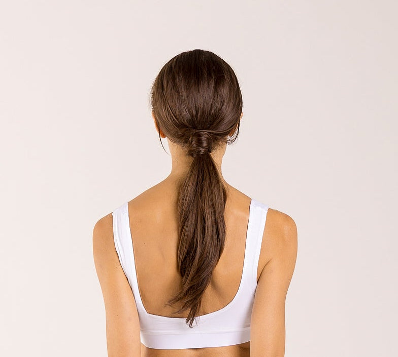 Woman wearing a white crop top made from seaweed to help alleviate the symptoms of menopause. 